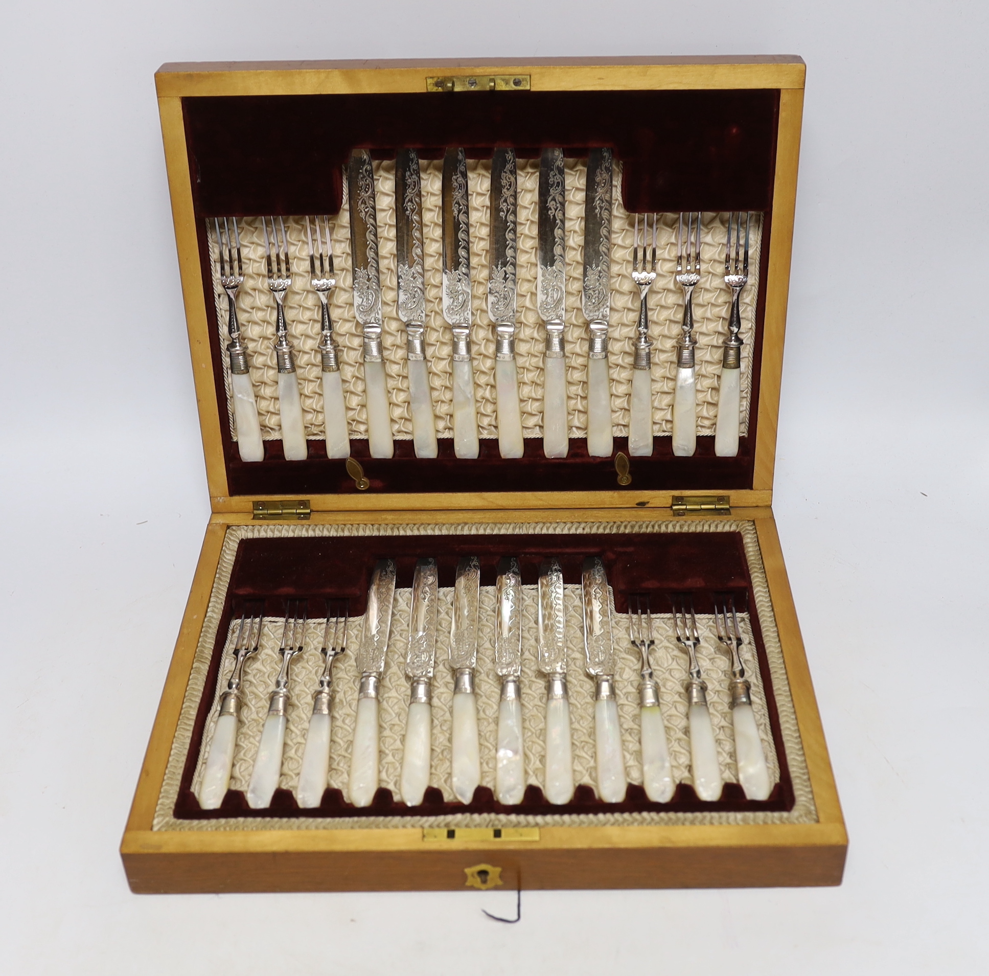An Edwardian cased set of mother of pearl handled plated dessert knives and forks with silver collars, Sheffield 1901